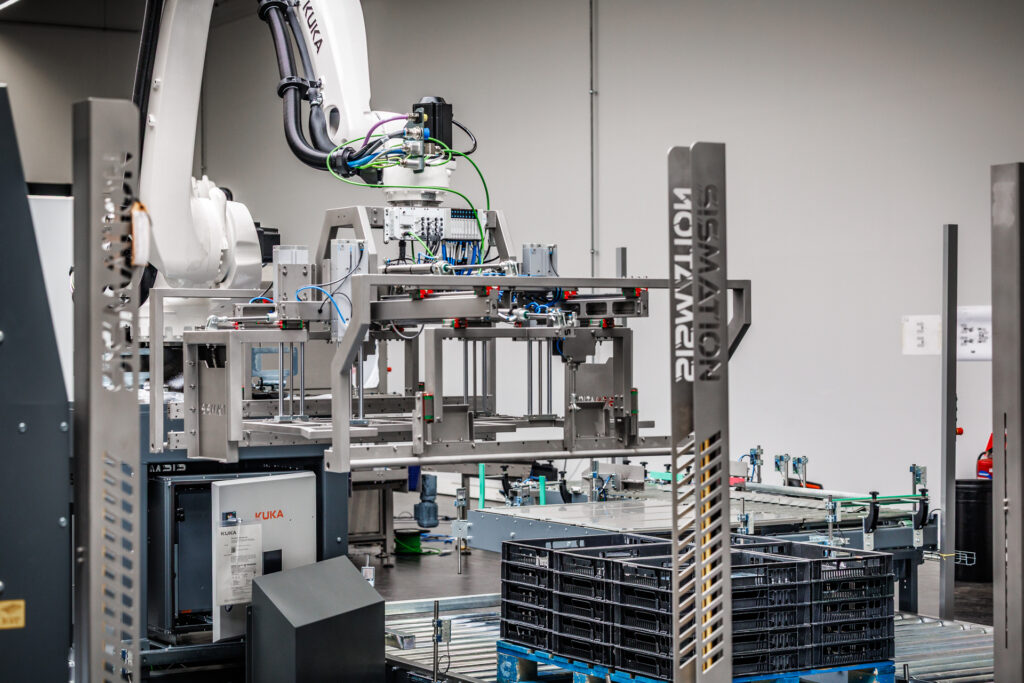 Robotgestuurde casepacker voor het automatisch vullen van kunststof kratten binnen een industriële verpakkingslijn.