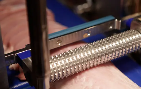 Gekartelde rol van een industriële vleesverwerkingsmachine voor het bewerken en mals maken van vleesproducten.